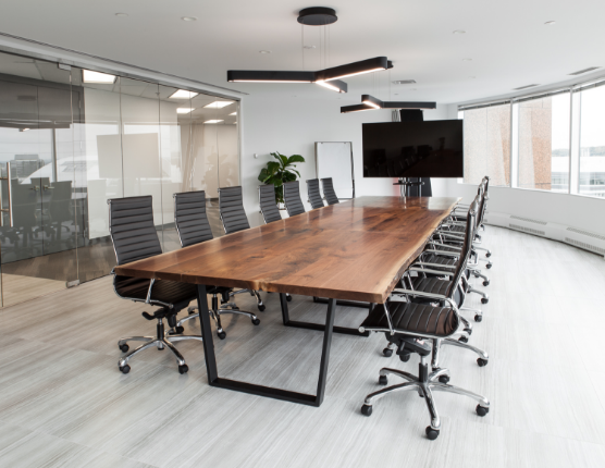 Acre Made's walnut live edge boardroom table styled with 14 office chairs 